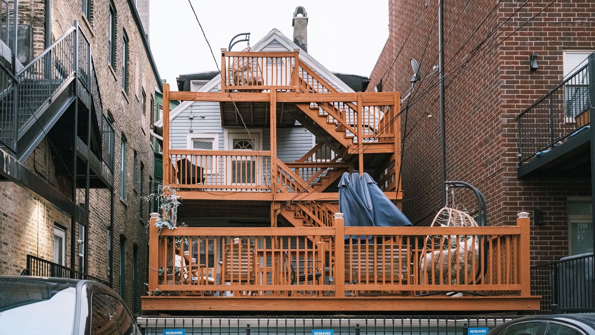 Multi-level wooden deck between urban buildings, showcasing unique architectural design.